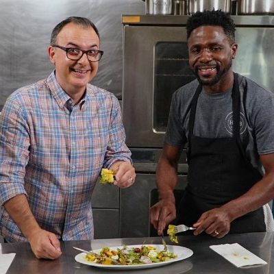 John Catucci posing for a photo shoot while eating the food.